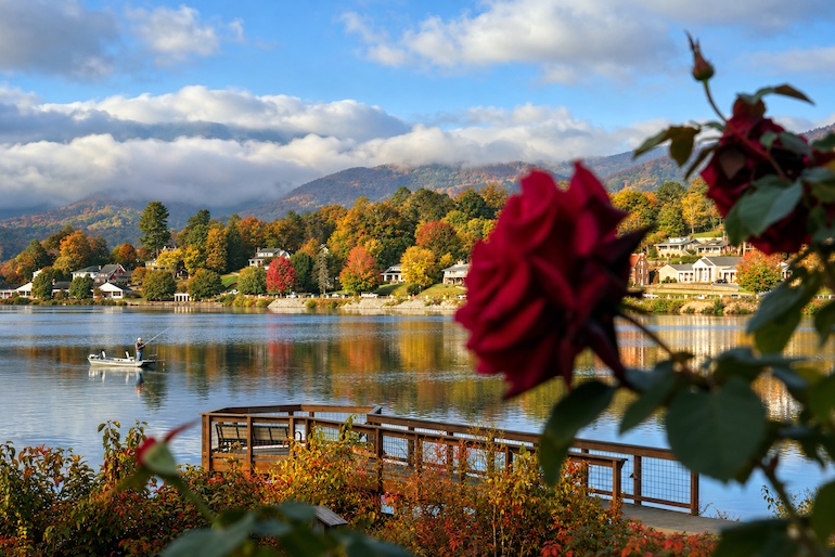 An angler fishes on Lake Junaluska as autumn colors spread across the surrounding mountains in Haywood County, North Carolina.