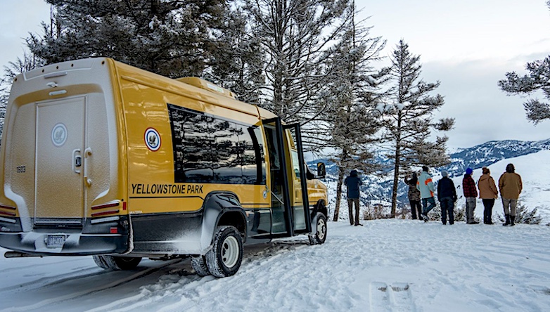 New winter arrivals take their first look at Yellowstone National Park while their yellow snowcoach waits to drive them to the Old Faithful Snow Lodge.